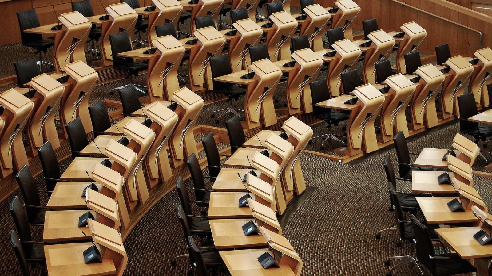 Imagem horizontal das mesas dentro do prédio do parlamento escocês