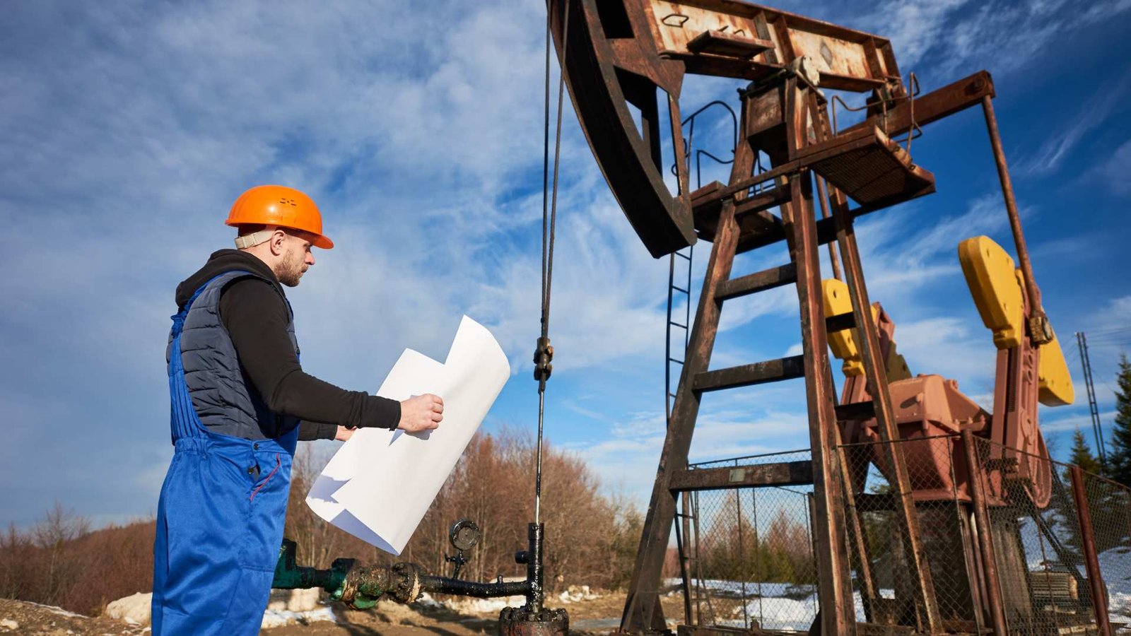 Homem do petróleo controlando o trabalho do jack da bomba