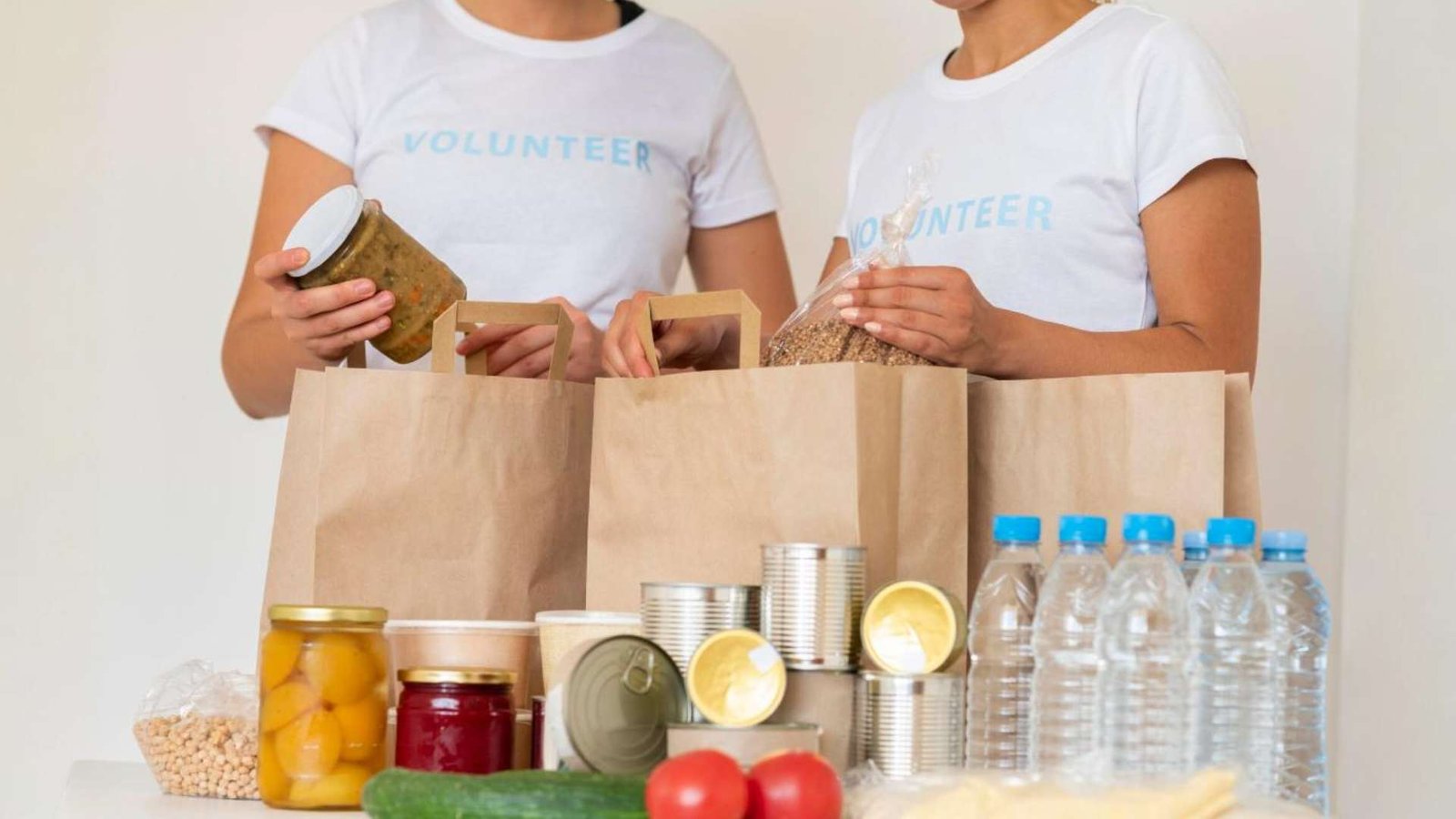 Voluntários com sacos de provisões e água para doação