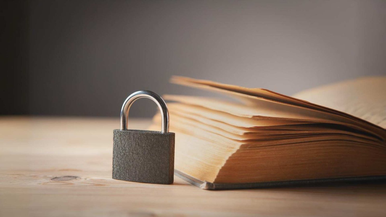 Livro e cadeado em uma mesa de madeira