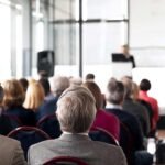 Pessoas sentadas no auditório durante a conferência