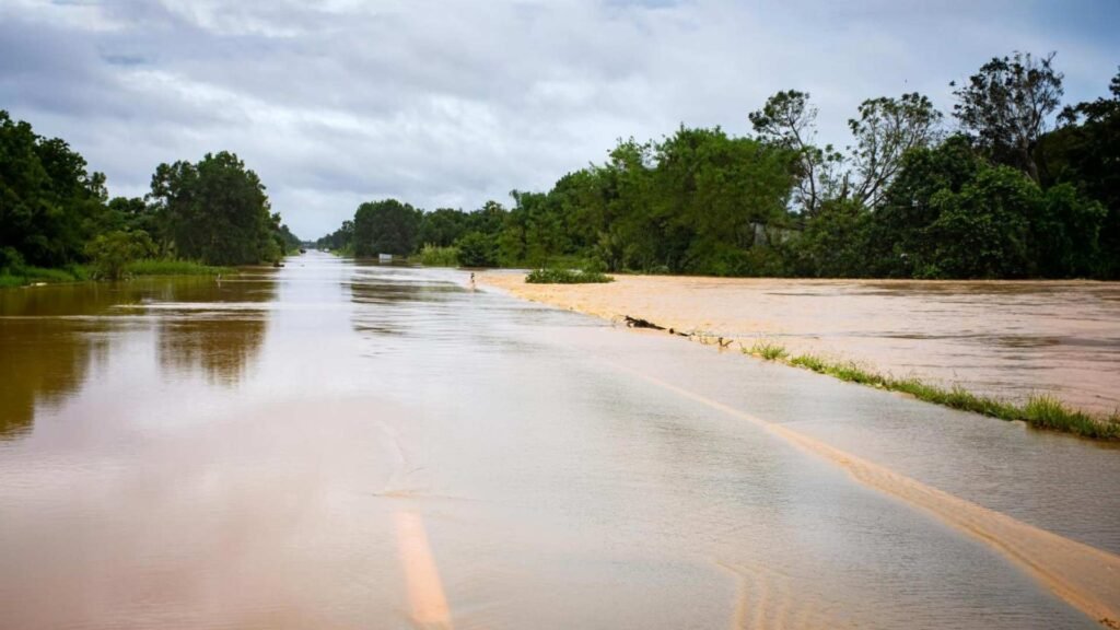 A água da inundação flui pela estrada após ventos fortes e ondas de tempestade