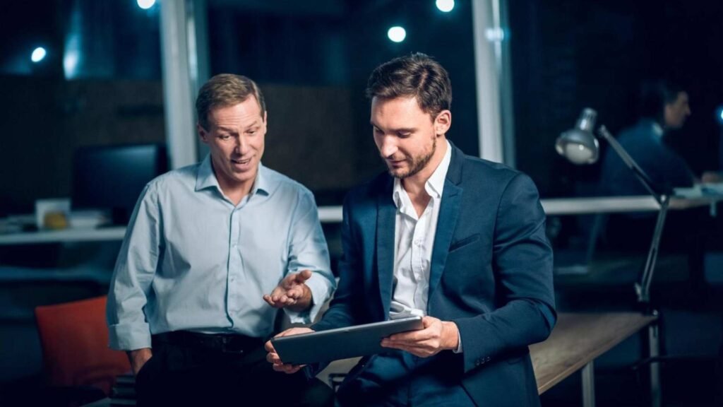 Dois trabalhadores de escritório com tablet no escritório tarde da noite